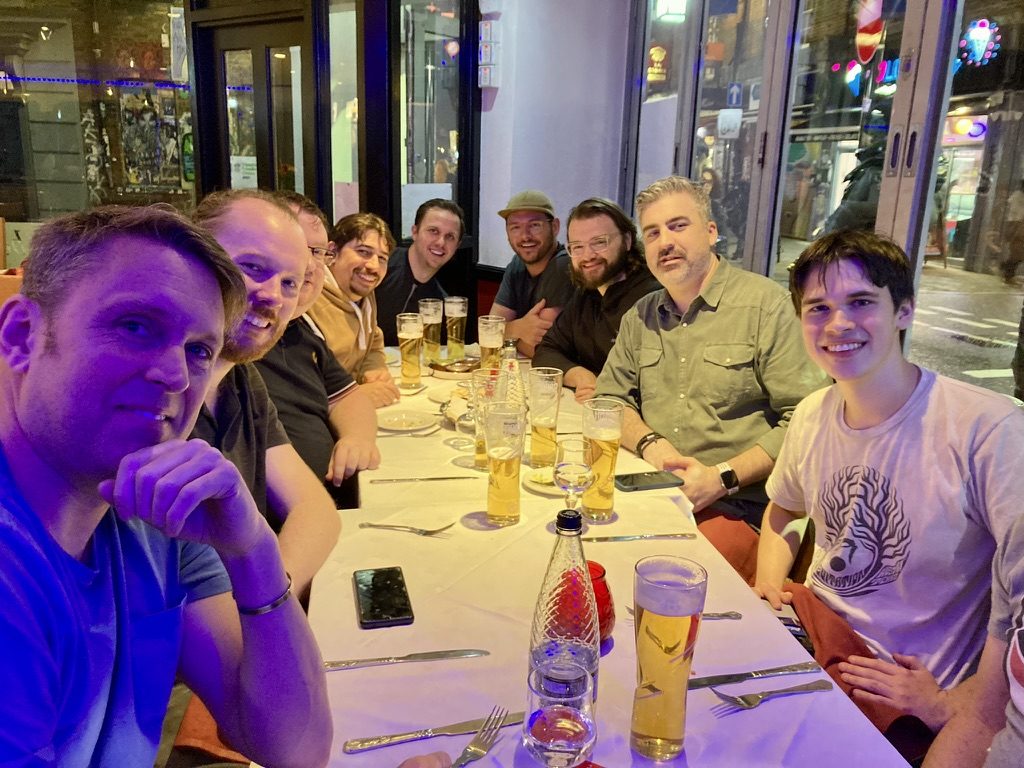 Austin Spurs members along one long table at dinner in London, pints poured and a lit street through the window.
